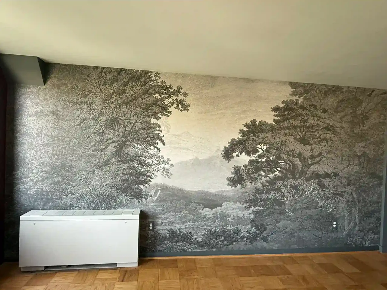 Monochrome landscape mural with tree silhouettes across a feature wall